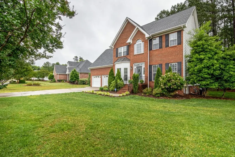 Lawn and shrubs, brick home